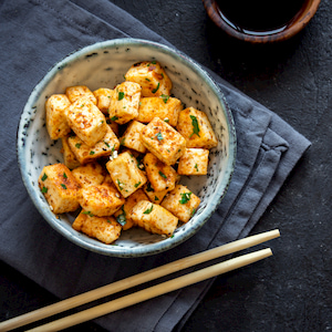 stir fried tofu in a bowl with sesame and greens