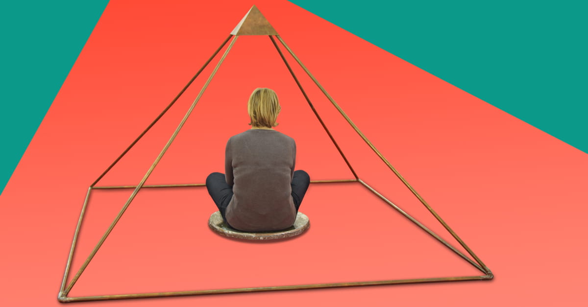 Woman meditating and making yoga in metal pyramid