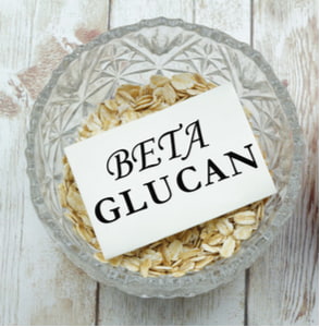 Rolled oats in a bowl with a piece of paper written Beta-Glucan on it
