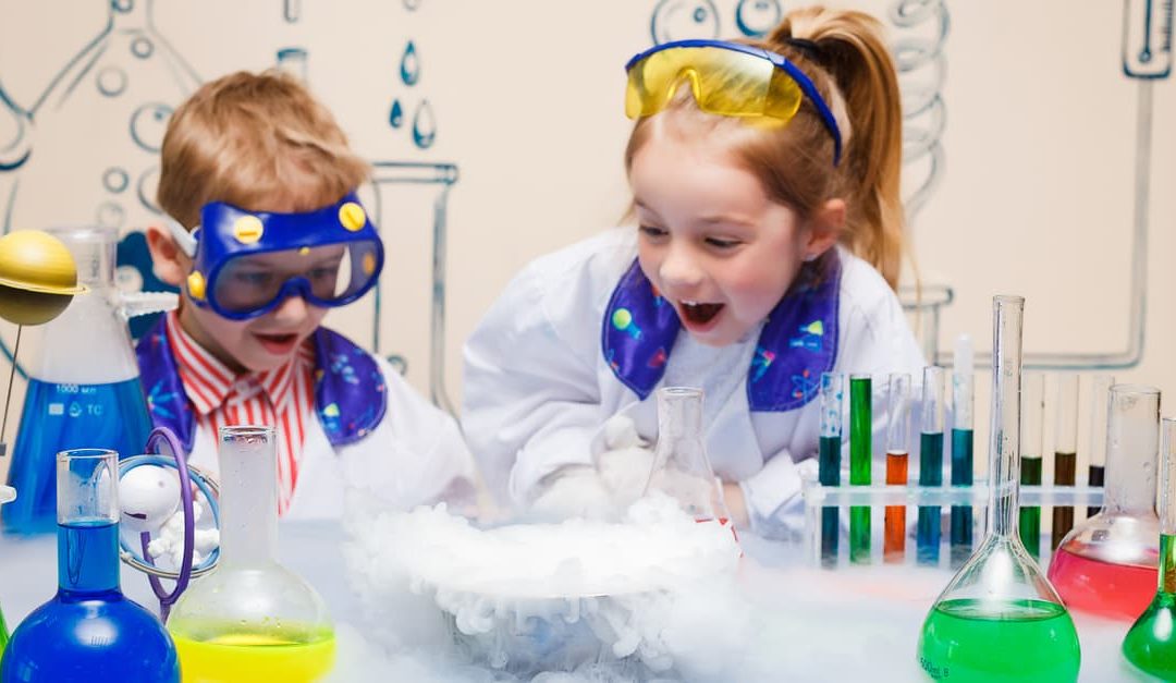Children doing science experiments with chemical fluids in the laboratory