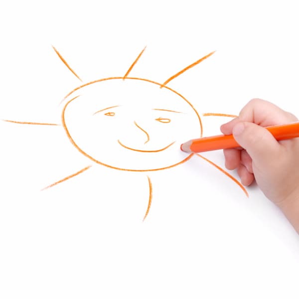 Childrens hand with pencil draws the sun for a weather chart