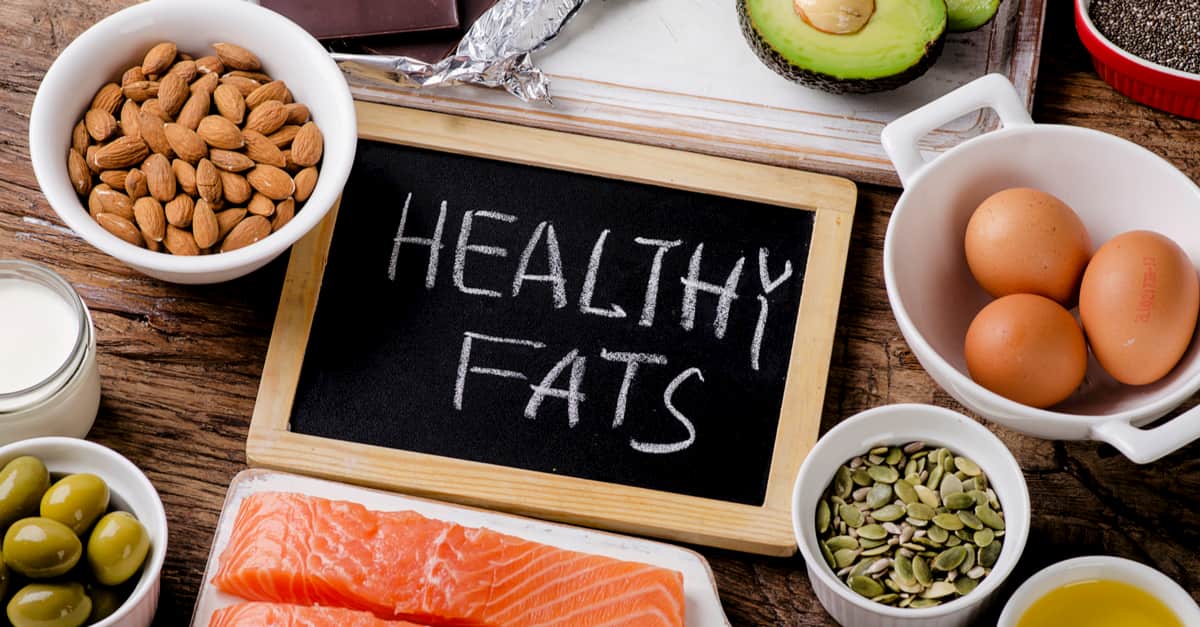 Selection of healthy fat sources on wooden background. 