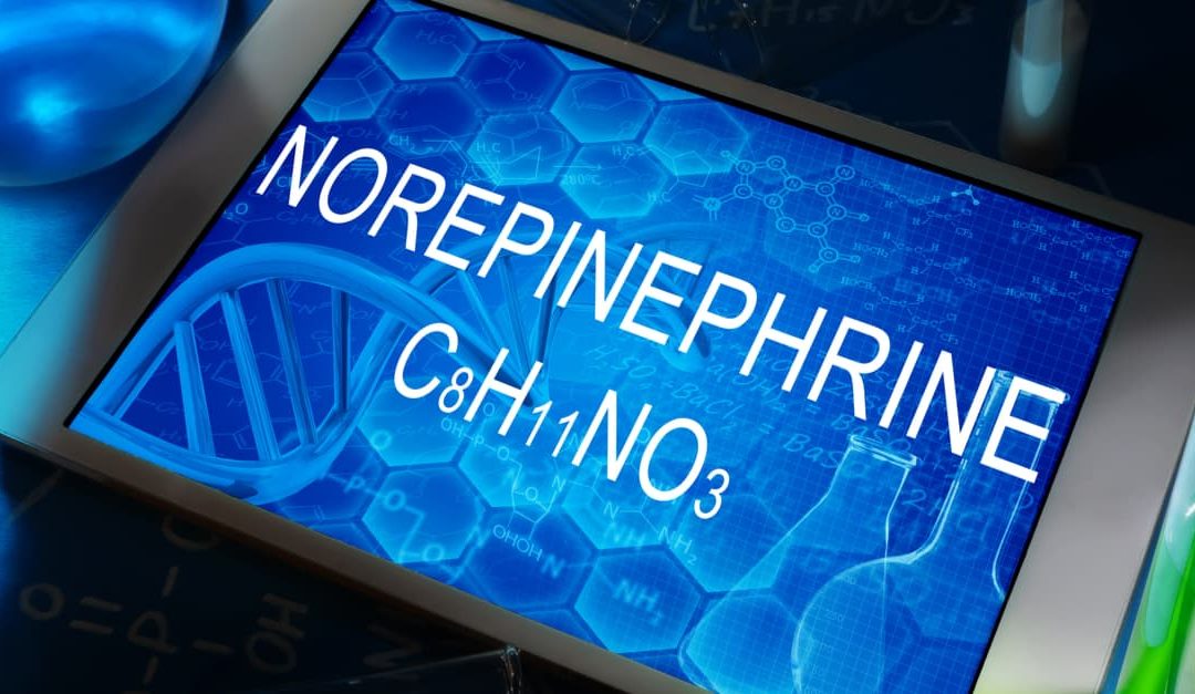 The chemical formula of Norepinephrine and test tubes on a tablet screen