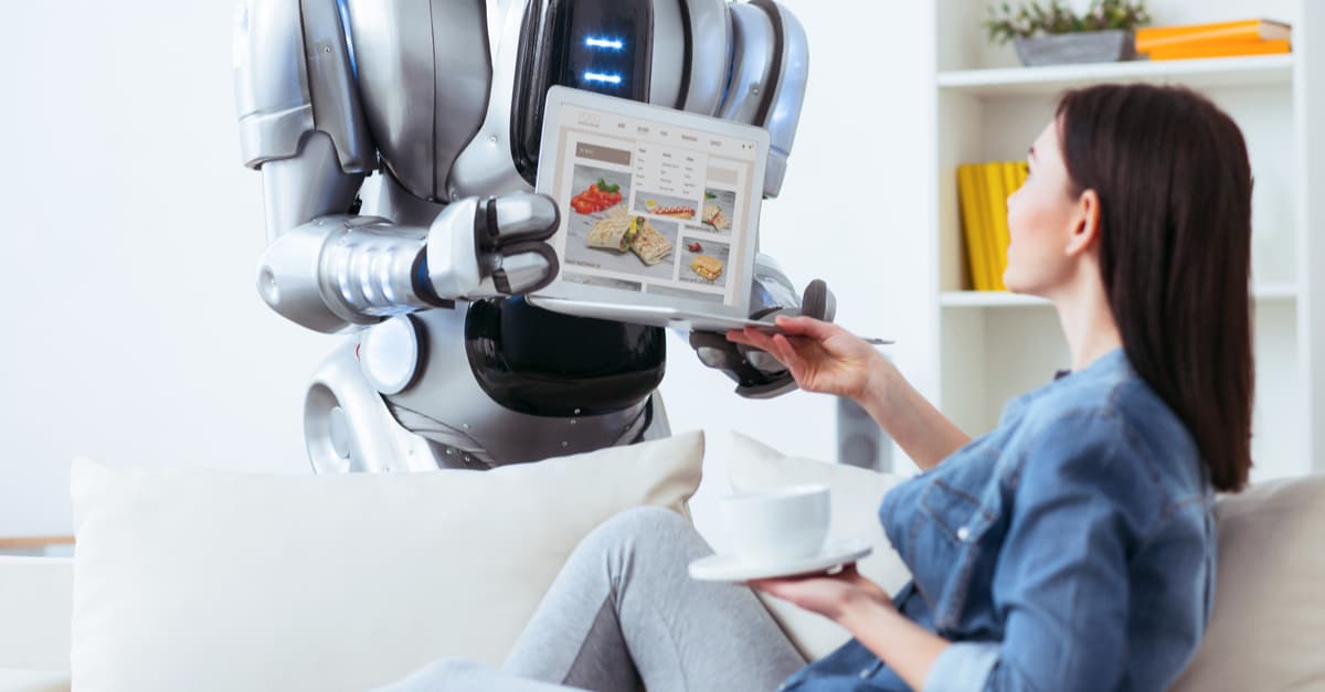 Woman sitting on her sofa using a Robotic Assistant